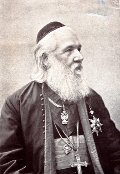 Portret istoric al Mitropolitului Ioan Mețianu, cu barbă albă și tichie, purtând cruce pectorală și decorații
